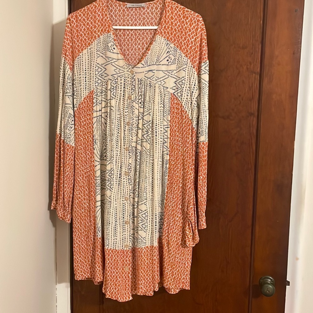 This is a long sleeve burnt orange and cream pocket dress